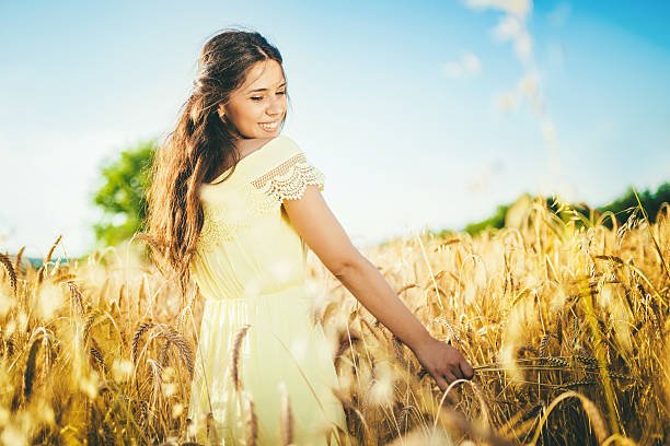 istock beautiful young woman at wheat field 576892352