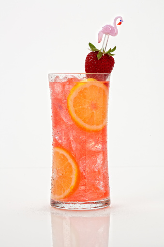 Strawberry Collins cocktail on a white background with a fresh strawberry garnish