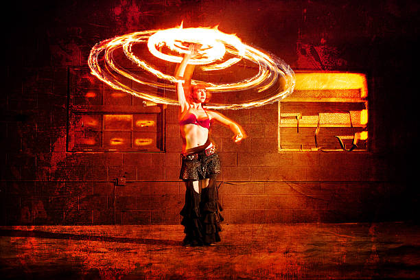 young latin woman fire performer holds in her hands fire fans over her head portrait
