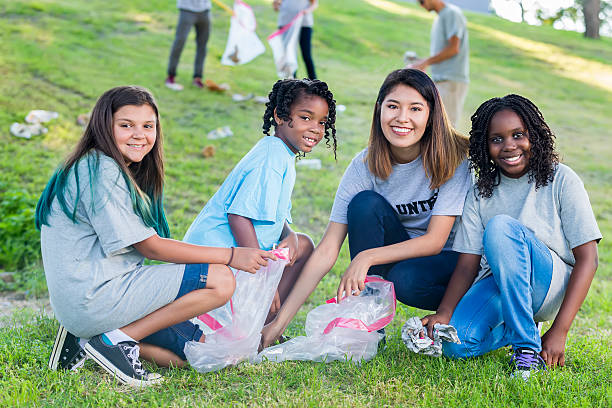 istock Woman and kids help clean up park 576893676