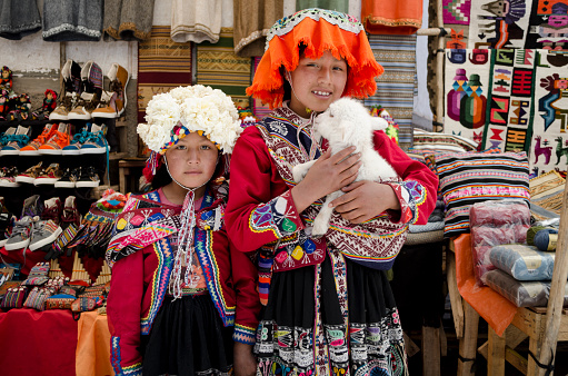 Pisac, Peru- October 6, 2015: Unidentified children with a lamb at Pisac market in Peru. Pisac is a village well known for its market every Sunday, Tuesday and Thursday.
