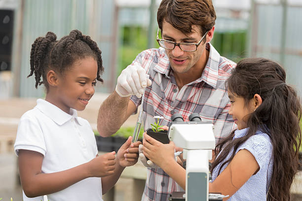 植物学者と学童がフィールドトリップ中に植物について話す - teaching field trip classroom child ストックフォトと画像