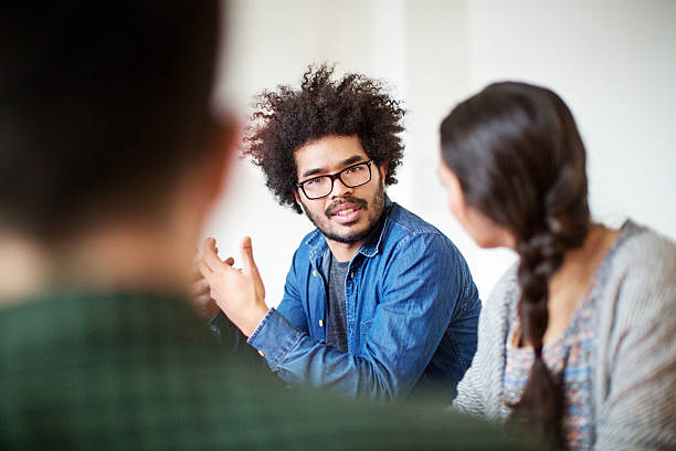 istock Young man sharing business ideas with colleagues in office 576902376