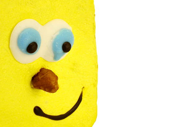 Close-up Of Single Brownie Cake With Human Smiling Yellow Face Isolated On White Background