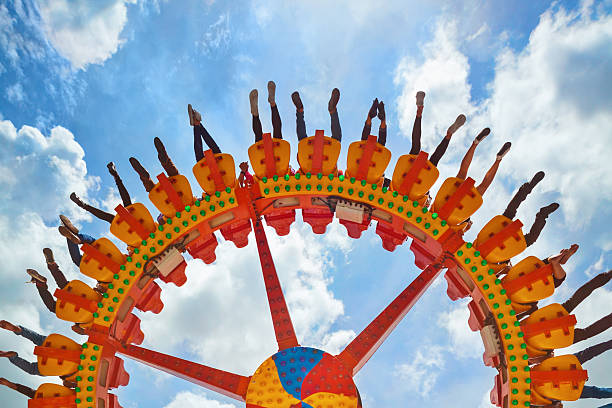 People riding with fun on extreme attraction in amusement park Funny photo of legs of women, men in amusement park riding with fun on extreme attraction swinging upside down high in air on sky background. Family lifestyle, people activity on holiday with children ferris wheel stock pictures, royalty-free photos & images