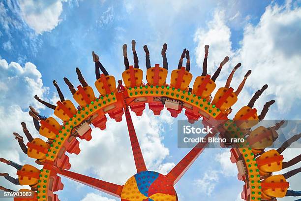 People Riding With Fun On Extreme Attraction In Amusement Park Stock Photo - Download Image Now