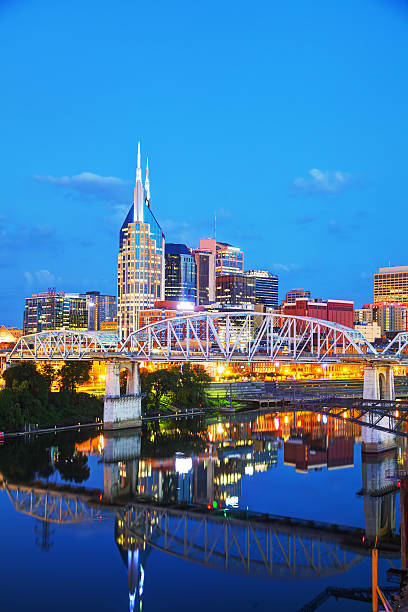 Downtown Nashville cityscape in the evening Downtown Nashville, Tennessee cityscape in the evening nashville tennessee bridge stock pictures, royalty-free photos & images