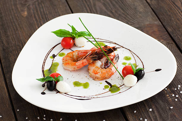 istock Grilled shrimps on white triangle plate, wood 576905542