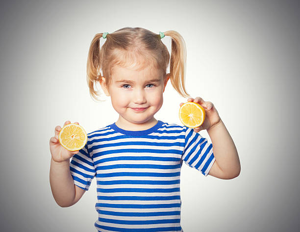 istock Little Funny girl keeps lemons 576905960