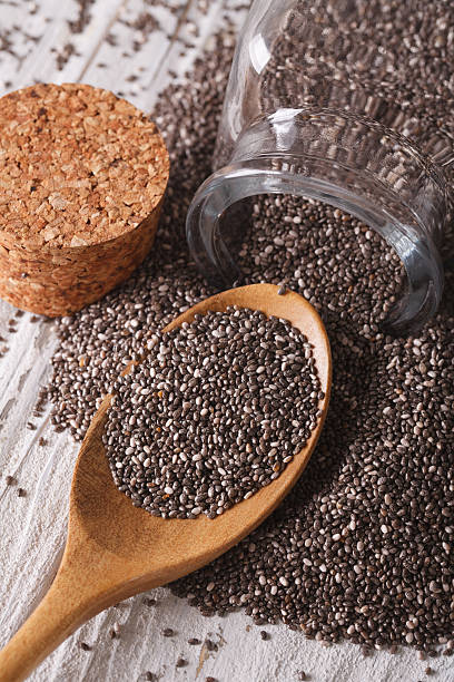 istock Chia seeds are poured out from a jar close-up. vertical 576906790