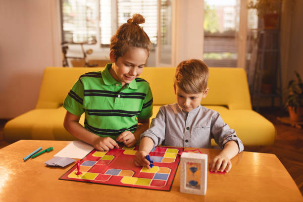 istock Two little brothers playing board game at the table. 576907828