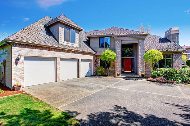 istock Large modern house with three garage spaces and concrete driveway. 576909072