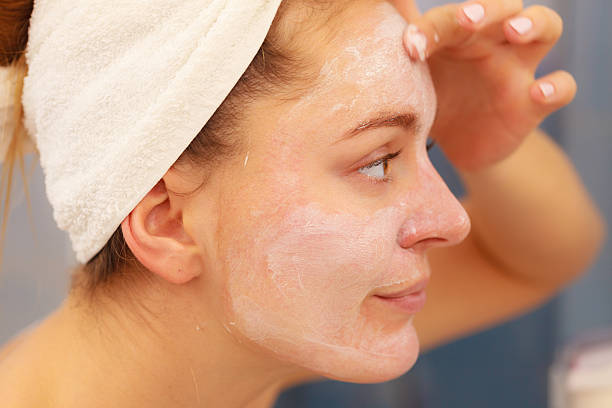 istock Woman applying mask cream on face in bathroom 576909718
