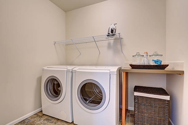 istock Small laundry room with white appliances and wicker basket 576910604