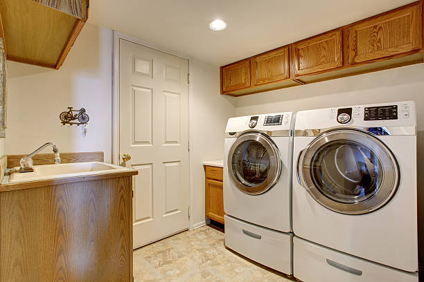 istock White laundry room interior with cabinets, sink and tile floor. 576912904