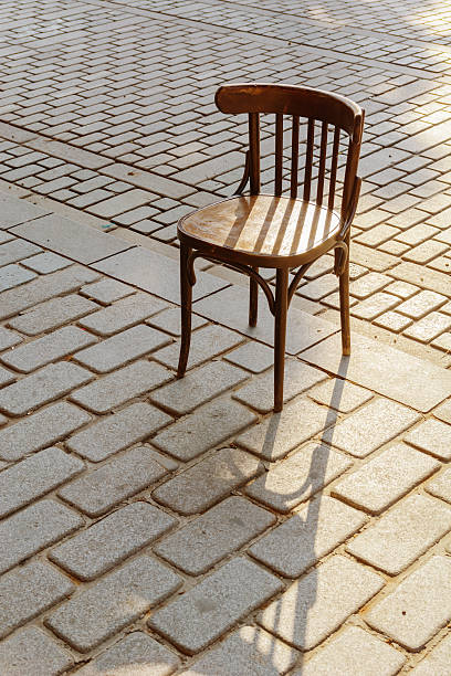 istock Old Viennese chair on the cobbles in the setting sun 576913144