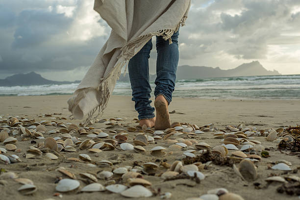 istock Female walking on beach at sunset 576916324