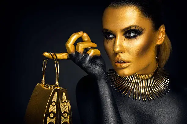 Photo of Beautiful woman portrait in gold and black colors