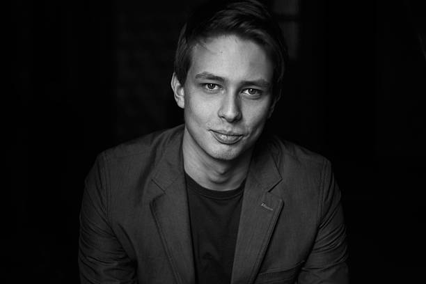 istock Handsome young man on dark background. Black and white photo 576920284