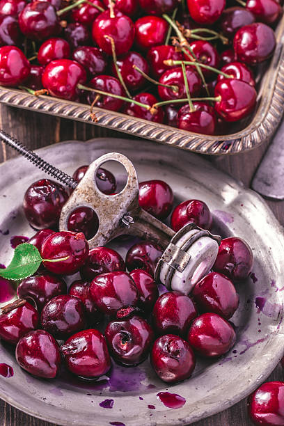 istock Cherries with old stone remover closeup 576920890