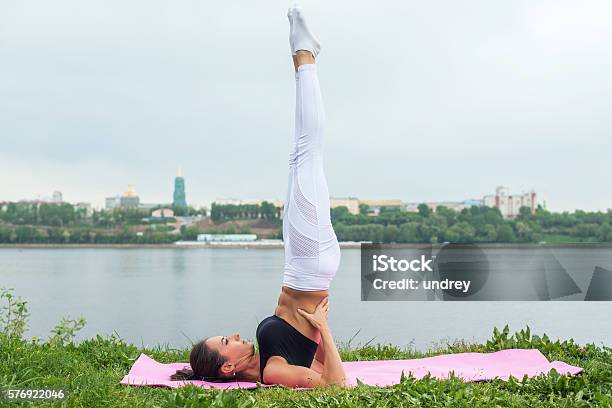 Fit Woman Making Yoga In Shoulderstand Pose Exercising In Nature Stock Photo - Download Image Now