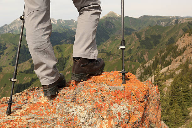istock successful woman hiker hiking on mountain peak cliff 576923402