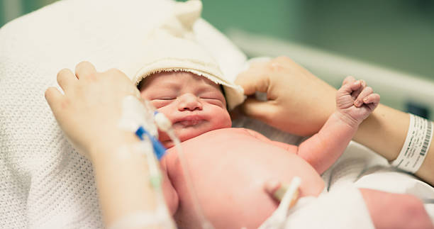 Newbon baby Baby in hand of mother while in hospital. home birth photos stock pictures, royalty-free photos & images