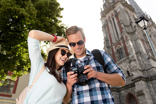 istock Joyful tourists watching photos in the camera 576923550
