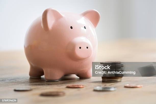 Coins Beside A Pink Piggy Bank To Deposit And Save Stock Photo - Download Image Now - Piggy Bank, Currency, Coin
