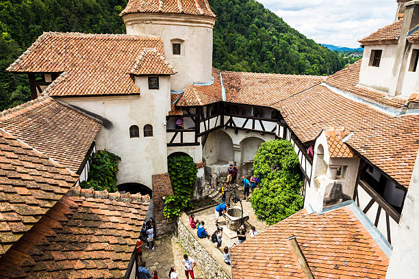 Bran Castle, Bran, in Transylvania, Romania Bran Castle, Bran, Romania - July 7, 2016: view of Bran Castle, Bran, Transylvania, Romania. The courtyard of the castle, traditionally associated with Bram Stoker's Dracula, is busy with summer tourists. bran stock pictures, royalty-free photos & images