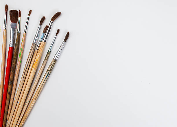 istock brushes for painting  and blank white paper sheet 576926860