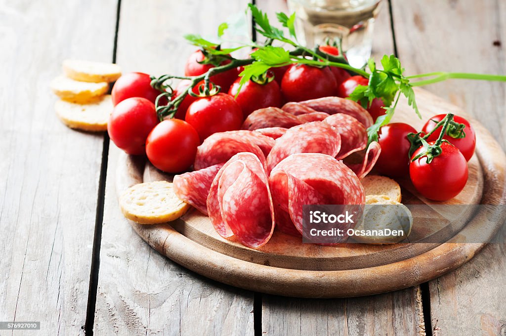 Fresh salami with tomato and bread Fresh salami with tomato and bread, selective focus Backgrounds Stock Photo