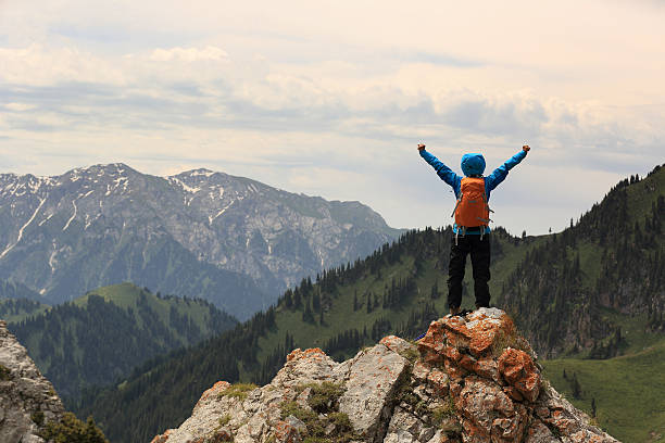 istock cheering successful woman backpacker open arms on mountain peak 576927914