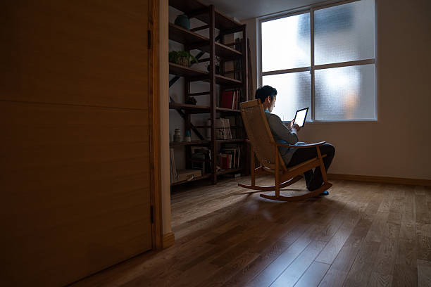 Man sitting alone in dark room using a digital tablet
