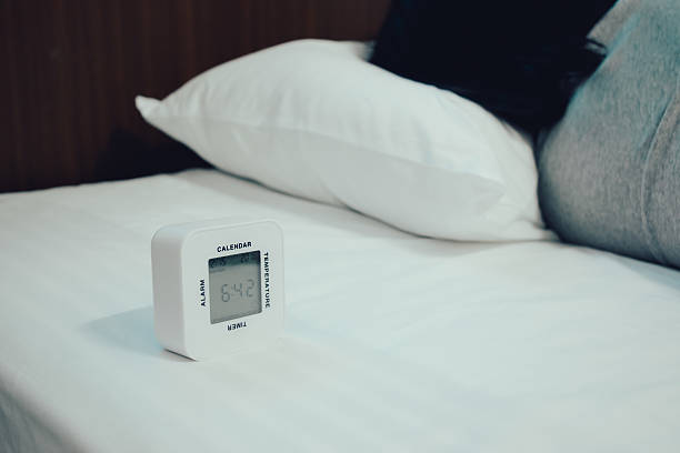 istock Young woman is sleeping with alarm clock 576928918