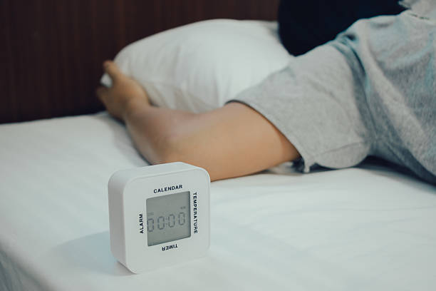 istock Young woman is sleeping with alarm clock 576929462