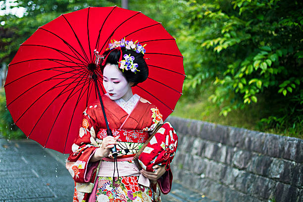 wunderschöne haltestelle maiko in den straßen von kyoto - parasol umbrella asian ethnicity asian culture stock-fotos und bilder