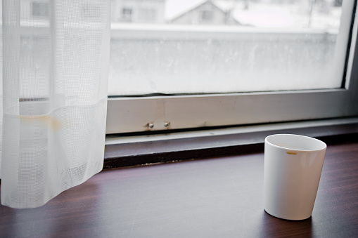 white coffe plastic cup on wood bar beside window at snowy day, Hakkaido, Japan