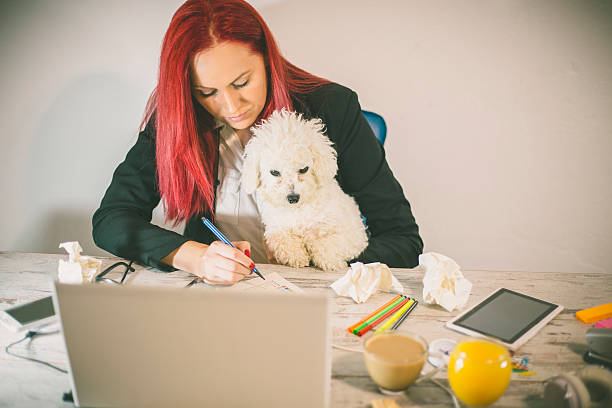 istock working at home office and holding her puppy 576936092