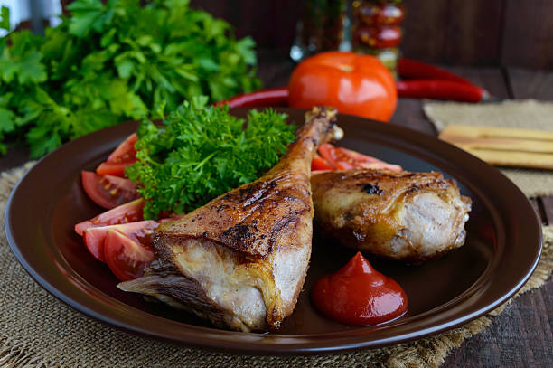 istock Roasted goose leg, sauce, herbs and tomatoes 576938300