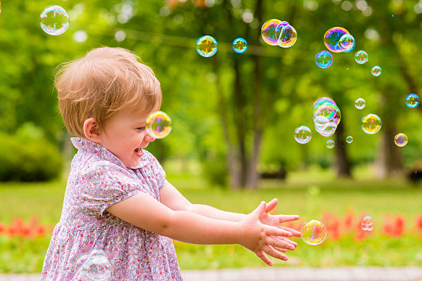 istock children's entertainment, Child playing with soap bubbles outsid 576938502