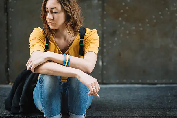 Photo of Sad girl smoking on stairs