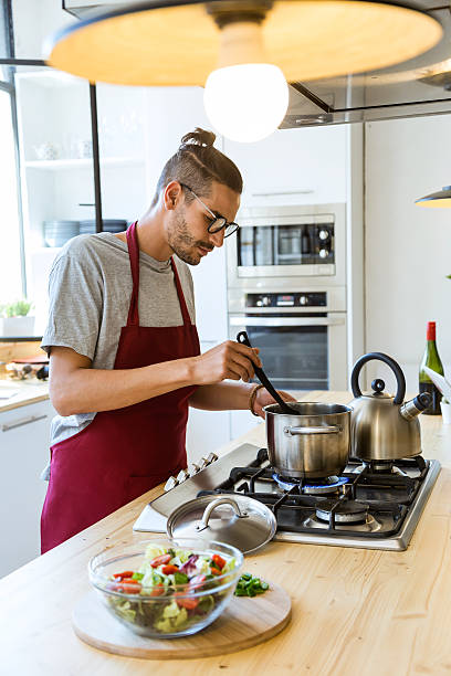 istock Handsome young man cooking in the kitchen at home. 577302520