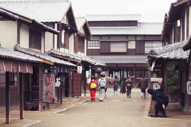 通りを歩く日本人と忍者 - chasing women men couple ストックフォトと画像