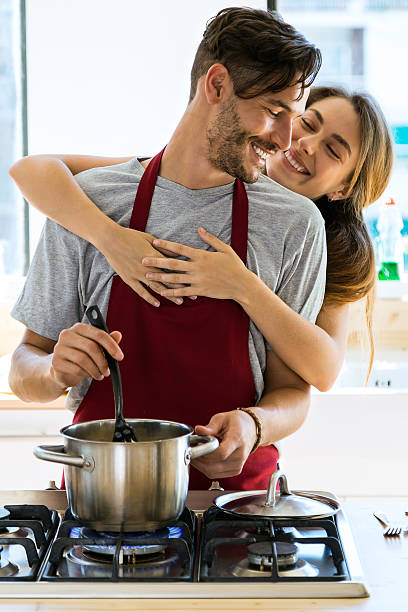 glückliches junges paar kochen zusammen in der küche zu hause. - standing digital tablet couple love stock-fotos und bilder