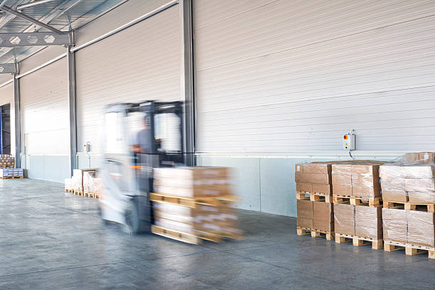 istock Coworkers carrying wooden boxes in warehouse. 577306512
