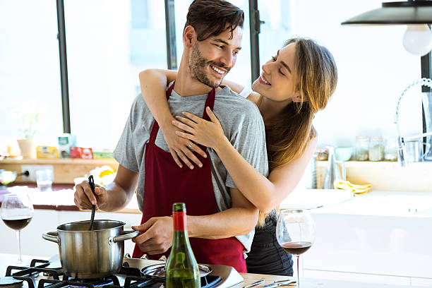 glückliches junges paar kochen zusammen in der küche zu hause. - standing digital tablet couple love stock-fotos und bilder