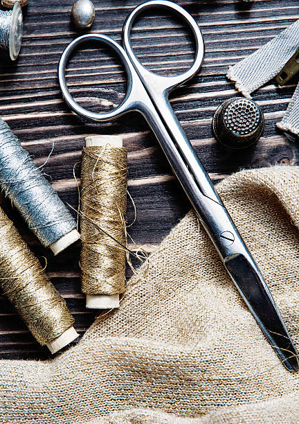 istock Sewing textile or cloth. Scissors reel of thread, and golden 577306772