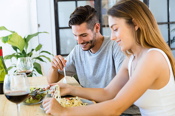 istock Happy couple dining and drink wine at home. 577306836