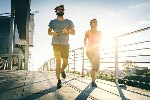 istock Young female and male running 577308776